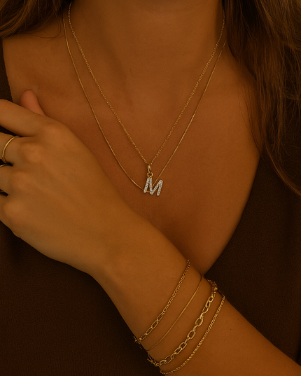Close-up of a person wearing gold necklaces and bracelets with a blurred background